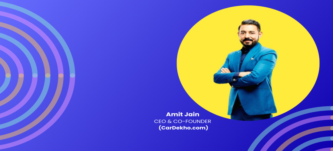 Amit Jain, blue-suited with arms crossed, embodies CarDekho's leadership evolution; data-light yet engaging.