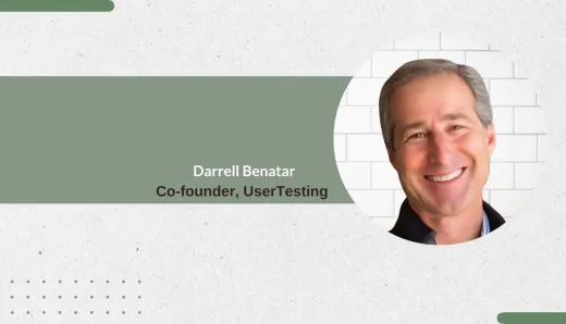 Darrell Benatar, Co-founder of UserTesting, smiling against a white brick background, highlighting his influential role in revolutionizing user experience testing.